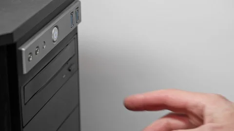 A male programmer takes out a CD-DVD from a computer drive. View from above Stock Footage 125814080