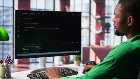 Male programmer types code on computer and running script Video stock 309112605