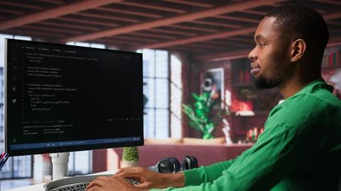 Male programmer types code on computer and running script Stockfoto's