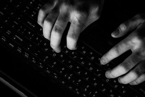 Male programmer working on desktop computer at white desk in office. Stock Photos