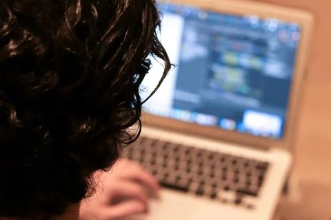 Male programmer working on laptop computer at desk in office, blurry backgrou Foto stock