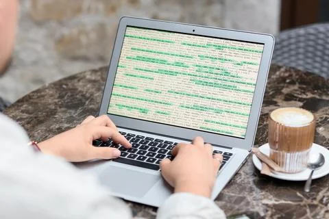 Male programmer working with laptop at table in street cafe, closeup Stock-Fotos