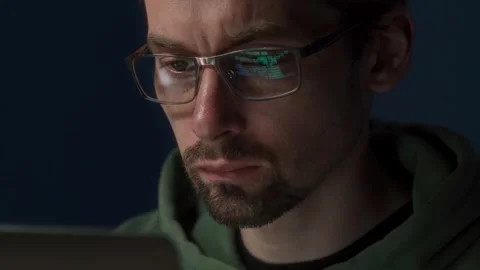 A male programmer is working late, analyzing data Stock Footage 303998435