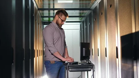 Male programmer works with a computer checking equipment at a data center. Stock Footage 111578857