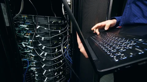 Male programmer works with a laptop, checking data center computer. IT support Stock Footage 111873064