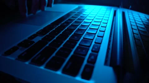 A male programmer writing code on a keyboard. Blue lighting, close-up Stock Footage 276488381