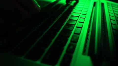 A male programmer writing code on a keyboard. Green lighting Stock Footage 277360782