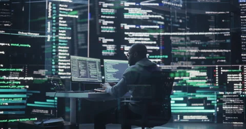 Male Programmer Writing Code Surrounded by Big Screens Stock Footage 243287299