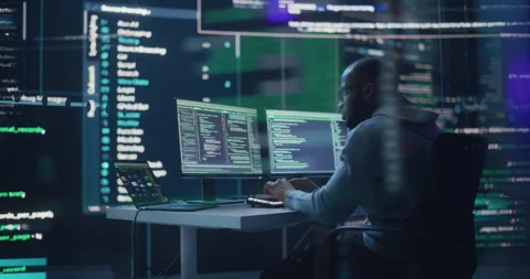 Male Programmer Writing Code Surrounded by Big Screens Stock Footage 243287775