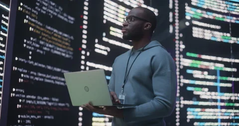 Male Programmer Writing Code Surrounded by Big Screens Stock Footage 243289205