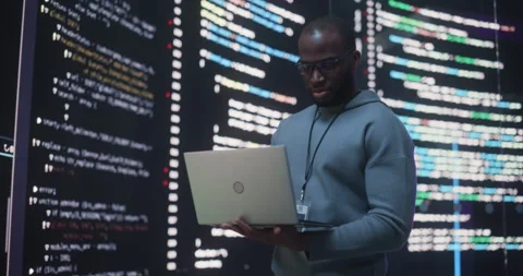 Male Programmer Writing Code Surrounded by Big Screens Video stock 243289256