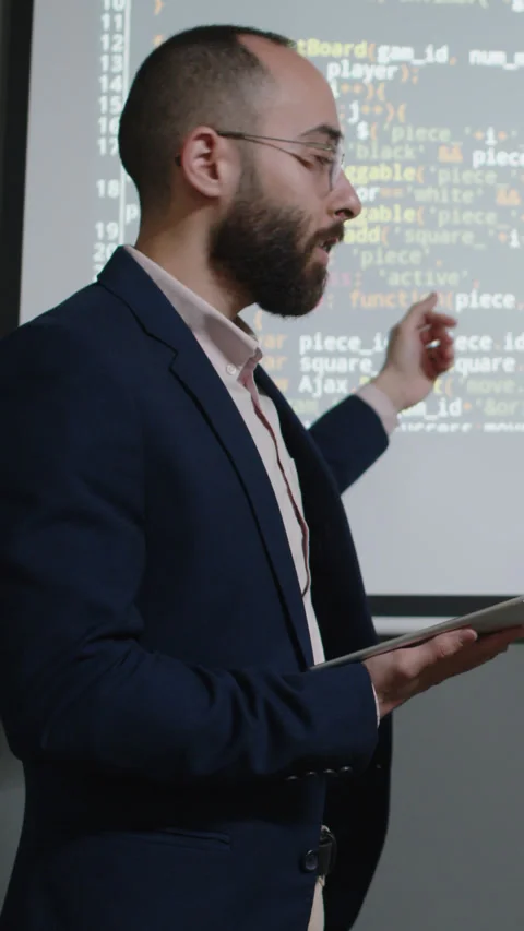 Male Programming Teacher Explaining Coding Sequence on Projector Screen Stock Footage 278584526