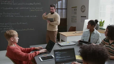 Male Programming Teacher Explaining Coding Principles to Diverse Students Stock Footage 318718677