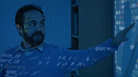 Male Programming Teacher Explaining Computer Code in Blue Projector Light Stock Footage 306979908