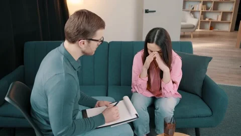 Male Psychologist notes during therapy session with sad female Video stock 236243086