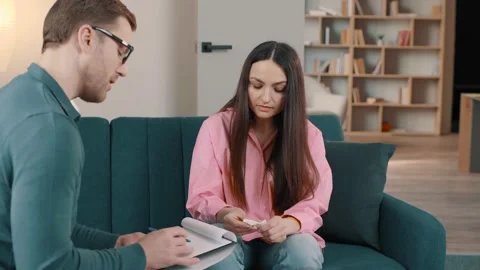 Male Psychologist notes during therapy session with sad female Video stock 236243161