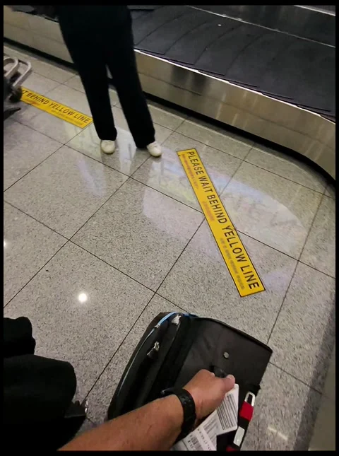 Male pulling a suitcase off the conveyor Stock Footage 310773230