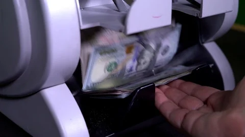 Male pulls out bills US dollar from money counter machine. Currency counting Stock Footage 115403604