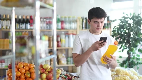 Male purchaser scanning QR code or barcode bottle of water in supermarket Stock Footage 310315901
