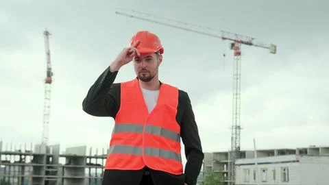 Male puts on work clothes, checking process at construction site Stock Photos