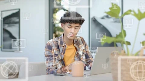 Male remote worker typing on laptop, causing tech icons to multiply, then using Stock Footage 333818013