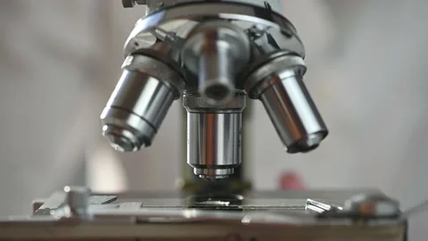 Male researcher looking at sample through a microscope in laboratory Stock Footage 143559963