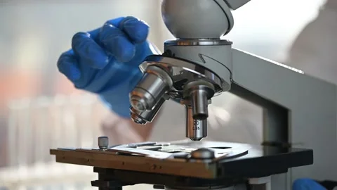 Male researcher looking at sample through a microscope in laboratory Stock Footage 143560233