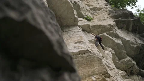 A male rock climber climbs up a rock Video stock 152562053