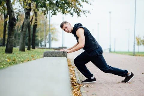 Male runner doing exercise, workout in the fall park. Push ups with bench Stock Photos