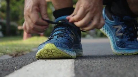 Male runner getting ready tying running shoes. Видео 107254163