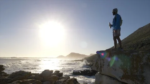Male runner resting after jogging onto a rocky outcrop Stock Footage 85618974