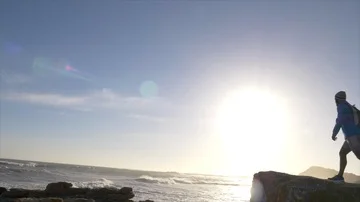 Male runner resting after jogging onto a rocky outcrop Stock Footage 85677178