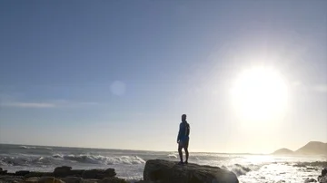 Male runner resting after jogging onto a rocky outcrop Stock Footage 85892016