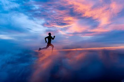 Male runner silhouette on fiery sunset backdrop Stock Photos