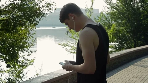 A male runner who trains and trains on a healthy lifestyle in the park stopped Stock Footage