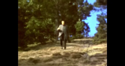 Male runs quickly down a slope in the forest Vídeo Stock 297965446