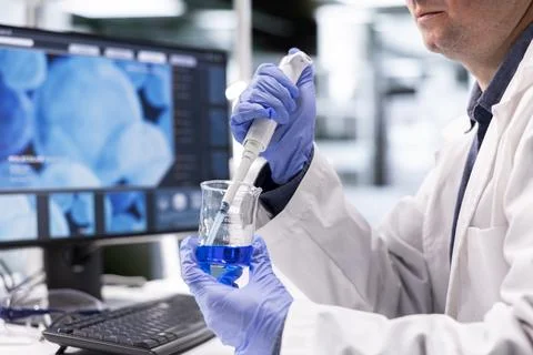 Male science expert prepares solution in jar with a lab pipette Stockfoto's