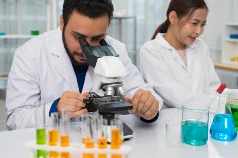 Male scientist with beard using microscope in laboratory Stock Photos