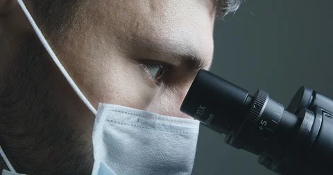 Male scientist looking at microscope 스톡 동영상 120411613