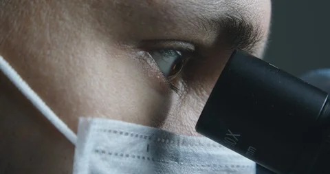 Male scientist looking at microscope Stock Footage 120411840