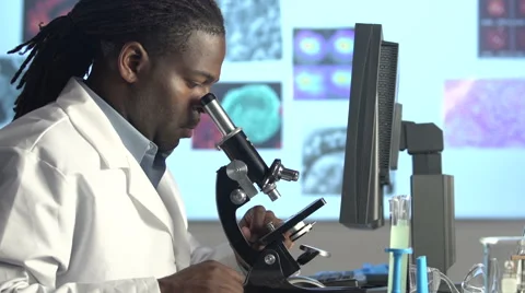 Male Scientist Looking through Microscope - dolly Stock Footage 41795557