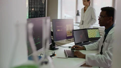 Male Scientist Programming on Computers, Working with Female Colleague in Lab Stock Footage 332361606