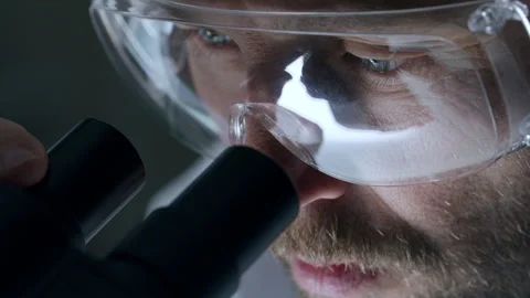 Male Scientist in Protective Goggles Looking through Microscope Binoculars Stock Footage 291232030