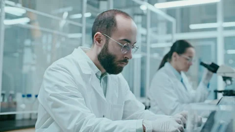 Male Scientist Typing Research Data on Laptop in Laboratory Stock Footage 331338012