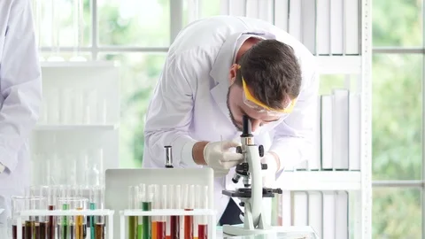 Male scientists are preparing microscopes for testing and analysis Stock Footage 106784150
