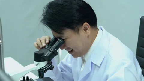 Male scientists looking through microscope. Stock Footage 106856758