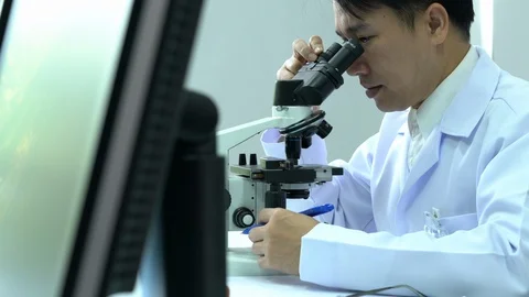 Male scientists looking through microscope. Stock Footage 106856837