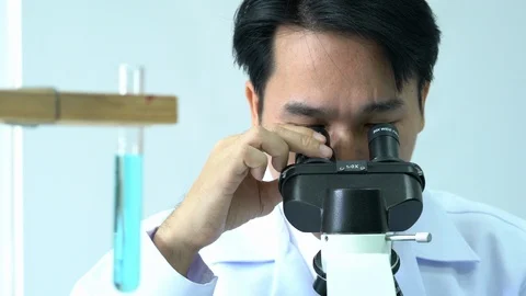 Male scientists looking through microscope. Stock Footage 106856949