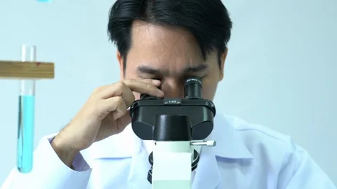 Male scientists looking through microscope. Stock Footage 106857127