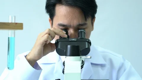 Male scientists looking through microscope. Stock Footage 106857241